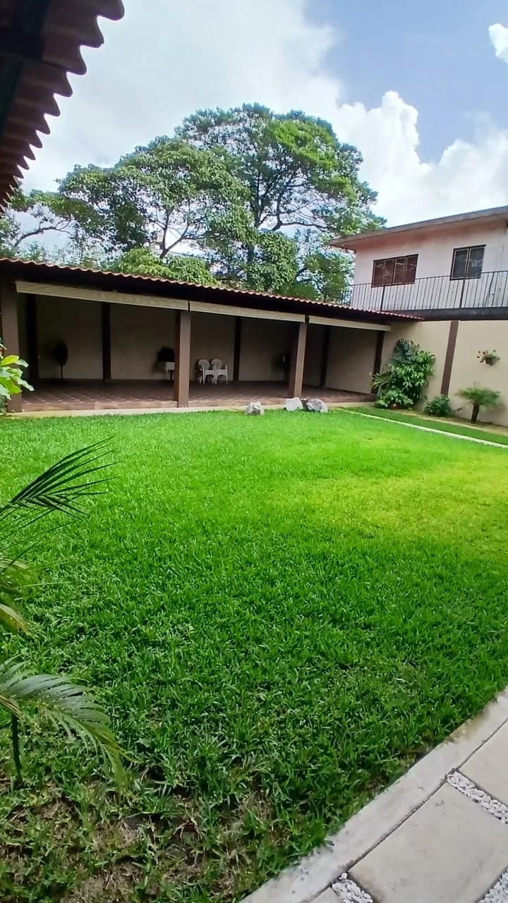 Vista amplia del jardín con el área de mesas al fondo
