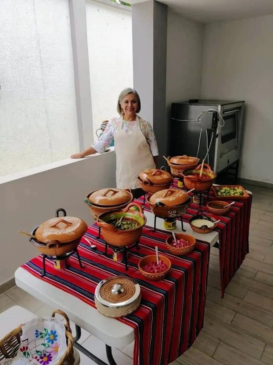 Mesa de taquiza con cazuelas de barro, guarniciones y salsas