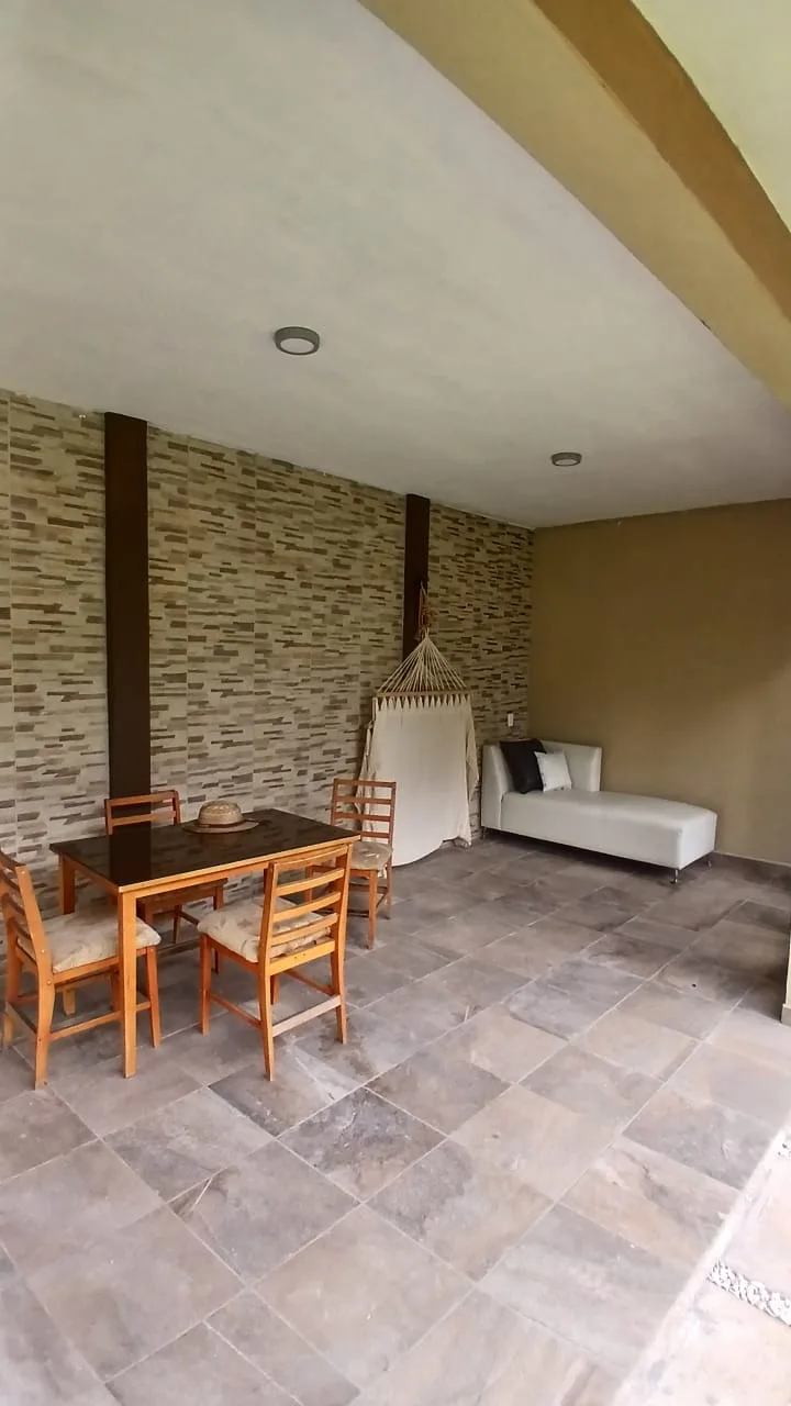 Zona lounge con hamaca y muro de piedra